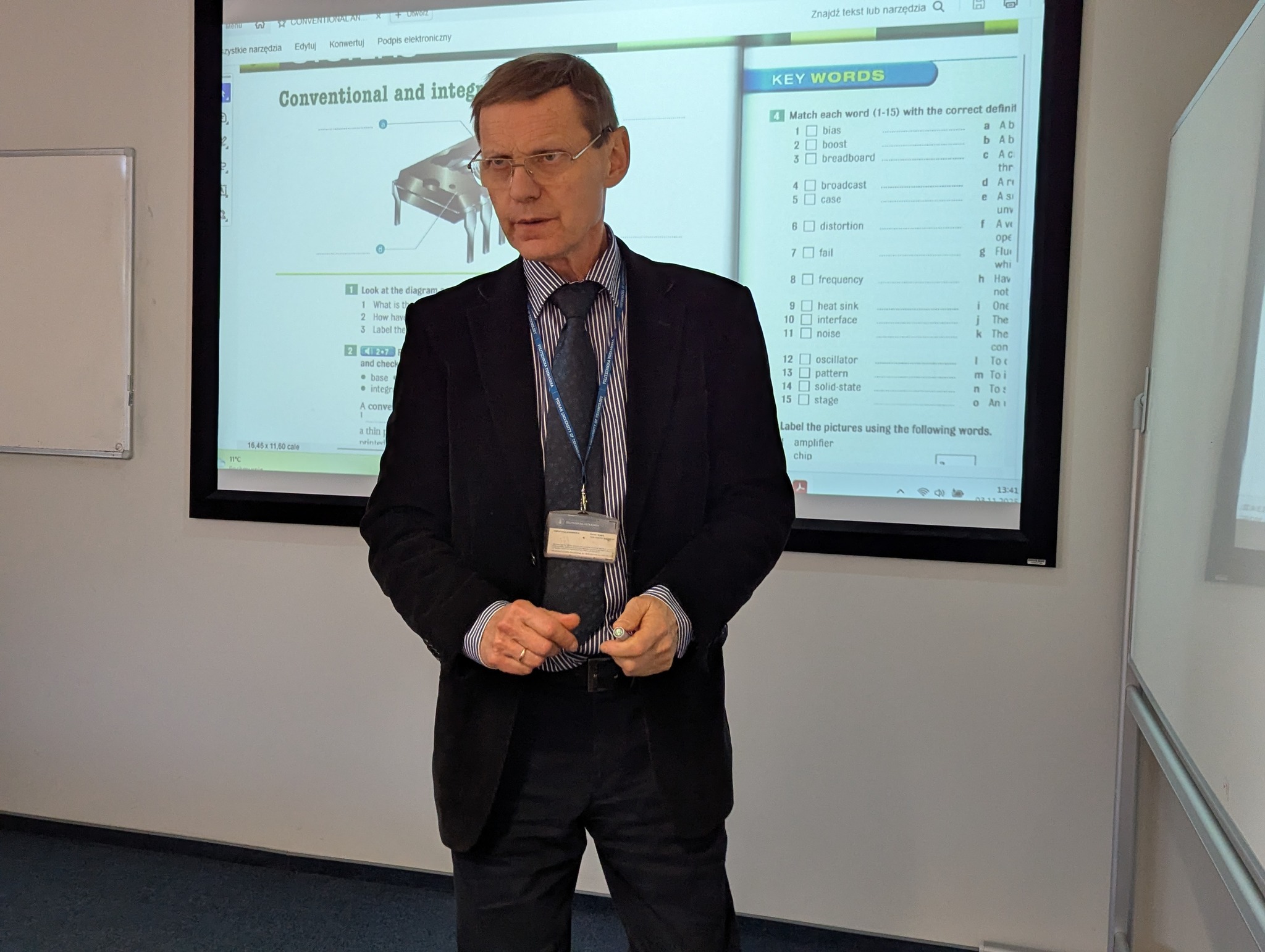 Zdjęcie przedstawia mgr Aleksandra Kubota, wykładowcę Centrum Języków i Komunikacji podczas zajęć ze studentami i uczniami w sali wykładowej.