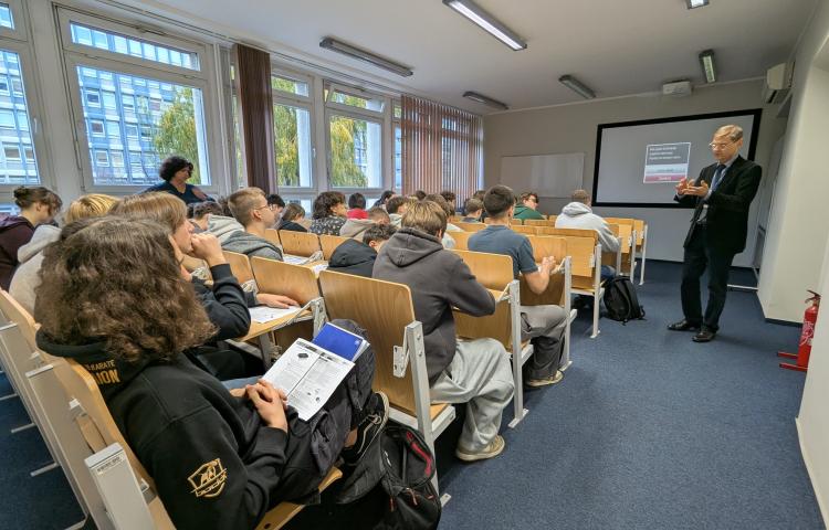 Zdjęcie przedsstwia wykładowce, studentów i uczniów V LO podczas zajęć.